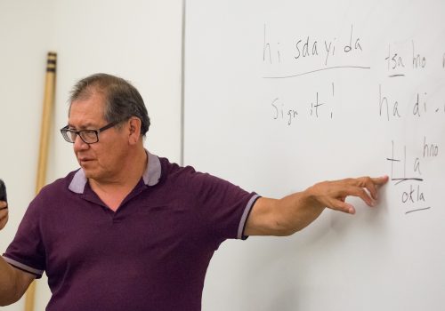 Professor teaching Cherokee at a whiteboard